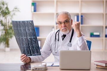 Old male doctor radiologist working in the clinic
