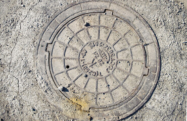 Closeup of rusty sewerage hatch. Manhole cover. Abstract grunge background