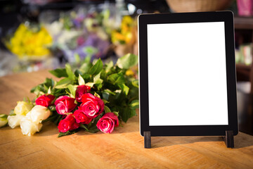 Digital tablet and flowers on table