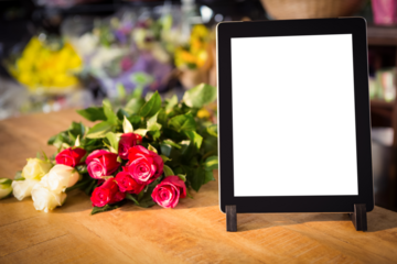 Digital tablet and flowers on table