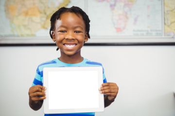 Boy holding digital tablet at classroom