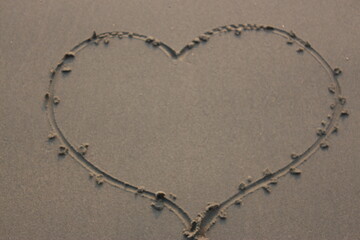 Heart shape on wet sand. Valentine's day background. Love concept.
