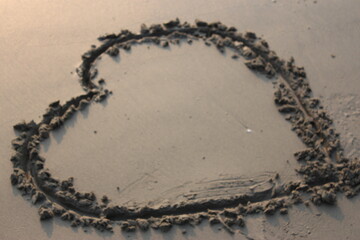 Heart shape on wet sand. Valentine's day background. Love concept.