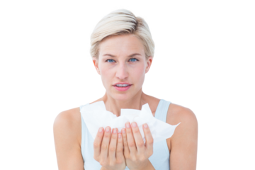 Sick woman holding tissues looking at camera