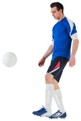 Football player in blue kicking ball