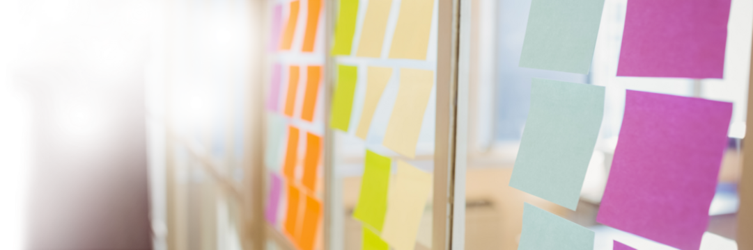 Close up of colorful adhesive notes on glass wall