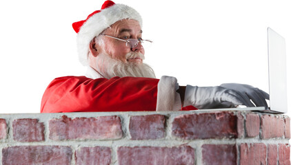 Santa Claus using laptop on chimney 