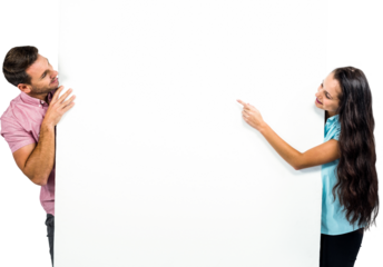 Smiling couple pointing on white sheet