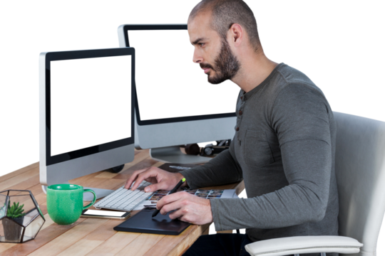 Male photographer using graphic tablet and computer at desk