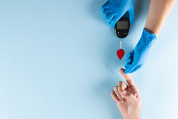 Hands of gloved doctor with glucometer taking blood sugar reading from caucasian woman, copy space