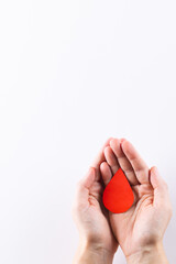 Hands of caucasian woman cupping blood drop, on white background with copy space