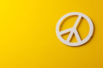 High angle view of white peace sign with copy space on yellow background