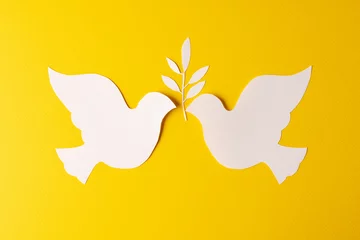 Schilderijen op glas Close up of two white doves with leaf and copy space on yellow background © vectorfusionart