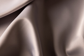 Close up of plain grey satin fabric with folds, copy space