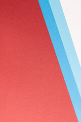Close up of white and blue paper on red background with copy space