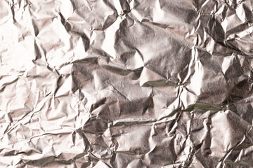 Close up of crumpled and shiny gold foil with copy space