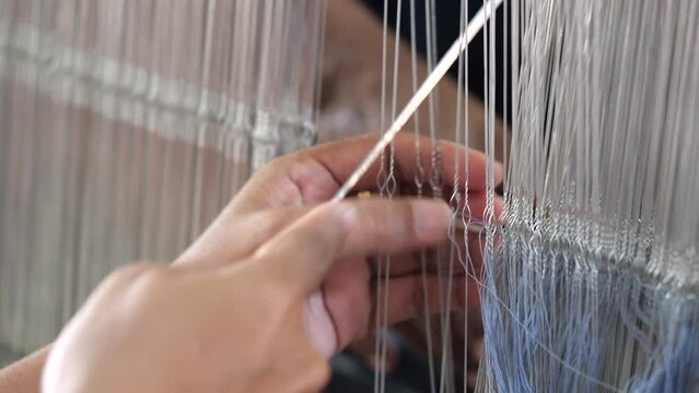 Selective focus traditional weaver is preparing yarn. Preparing the loom before starting to make woven ikat