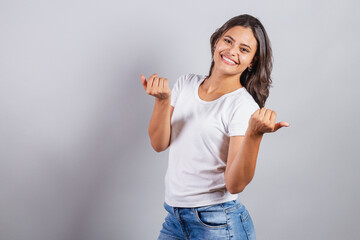 beautiful brazilian woman. denim and white. inviting with hands, calling, welcome. come, welcoming, presenting.