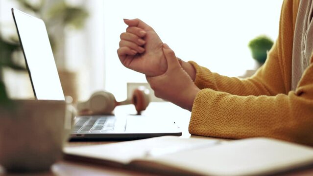 Businesswoman working in the office with wrist pain, injury or accident typing on a laptop. Technology, professional and closeup of a female employee with sprain hand doing research in the workplace.