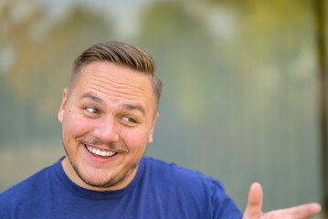 Teasingly smiling young man pointing at someone