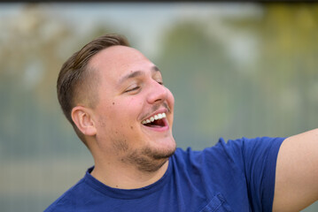 Young man happily waving to someone