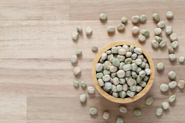 Top view of green peas in a bowl on wooder background, Healthy eating concept