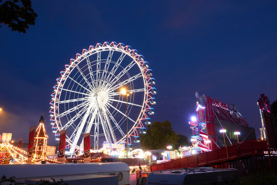 View of ferris wheel of folk festival, amusement ride against sky in blue. Stuttgart, Bad Cannstatt, Germany.