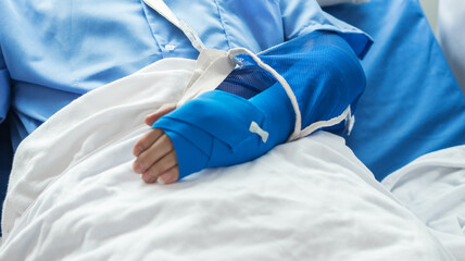 Cropped image of doctor in uniform with stethoscope using tablet standing in hospital with patient lying in bed on background Operator checks patient information on digital tablet