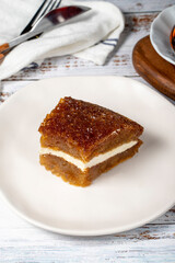 Bread pudding on wood floor. Traditional Ramadan dessert. Bread kadayif with cream in the middle. Local name kaymaklı ekmek kadayifi