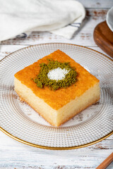 Revani dessert on wood background. Traditional Ramadan dessert. Revani dessert with pistachio and coconut. Close up