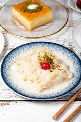 Güllaç, revani, tulumba and bread kadayif dessert with cream on a wood floor. Ramadan sweets. Traditional Turkish cuisine delicacies