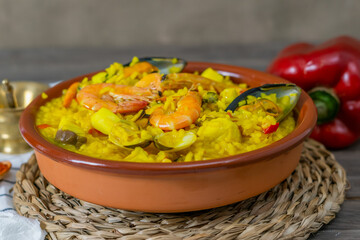 portion of typical spanish seafood paella in a clay casserole