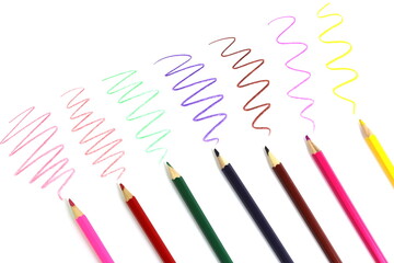Colored pencils with drawn scribbles lie on a white isolated background.