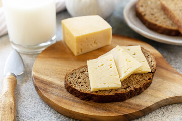 Healthy food concept, breakfast, superfood. Fresh whole grain bread with cheese and a glass of almond milk on stone table.