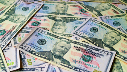 Heap of United States fifty dollar bills with selective focus and blurred background