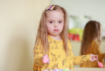 Portrait of a girl with Down syndrome. Cute happy girl with long hair.
