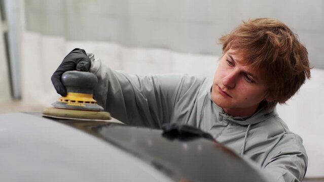 mechanic worker repairman sanding polishing car and preparing automobile for painting