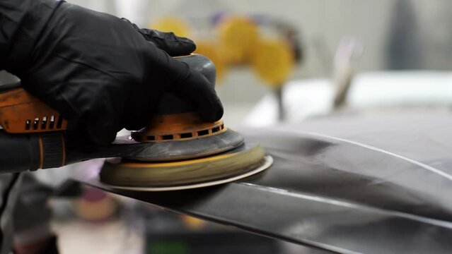 close up, Auto mechanic grinds car part for painting. Car body work auto repair paint after accident