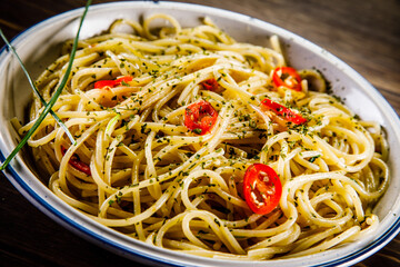 Spaghetti with chili and olive oil on wooden background