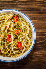Spaghetti with chili and olive oil on wooden background