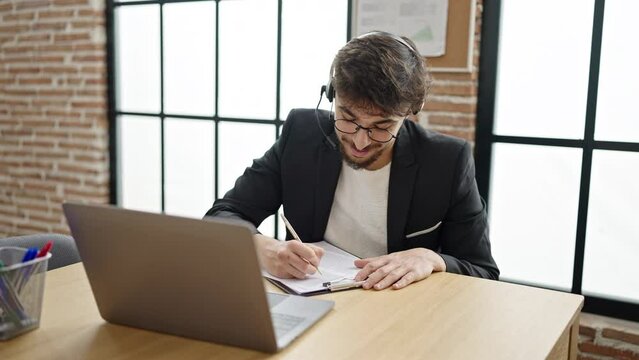 Young arab man business worker having video call writing on document at office