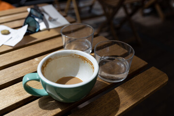 Empty coffee cup after drink on a wooden table. Concept for ending a meeting or something else. Cafe culture.