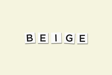The word BEIGE, spelt with letter Scrabble tiles on a beige background
