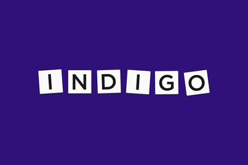 The word INDIGO, spelt with letter Scrabble tiles on a indigo background