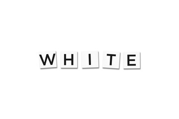 The word WHITE, spelt with letter Scrabble tiles on a white background