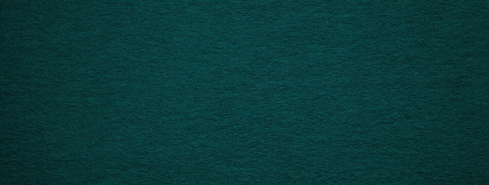 Texture of old dark green paper background, macro. Structure of a vintage craft teal cardboard. Grunge emerald carton