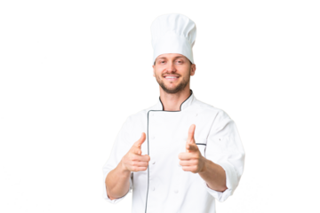Young caucasian chef over isolated chroma key background pointing to the front and smiling