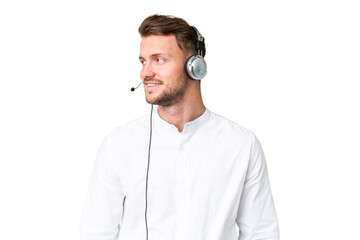 Telemarketer caucasian man working with a headset over isolated chroma key background looking side