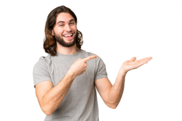 Young handsome man over isolated chroma key background holding copyspace imaginary on the palm to insert an ad