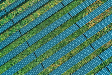 A top-down aerial view of solar panels providing green energy with modern technology installed in a solar farm. Alternative renewable energy. Ecology solar panels, electrical innovation environment.